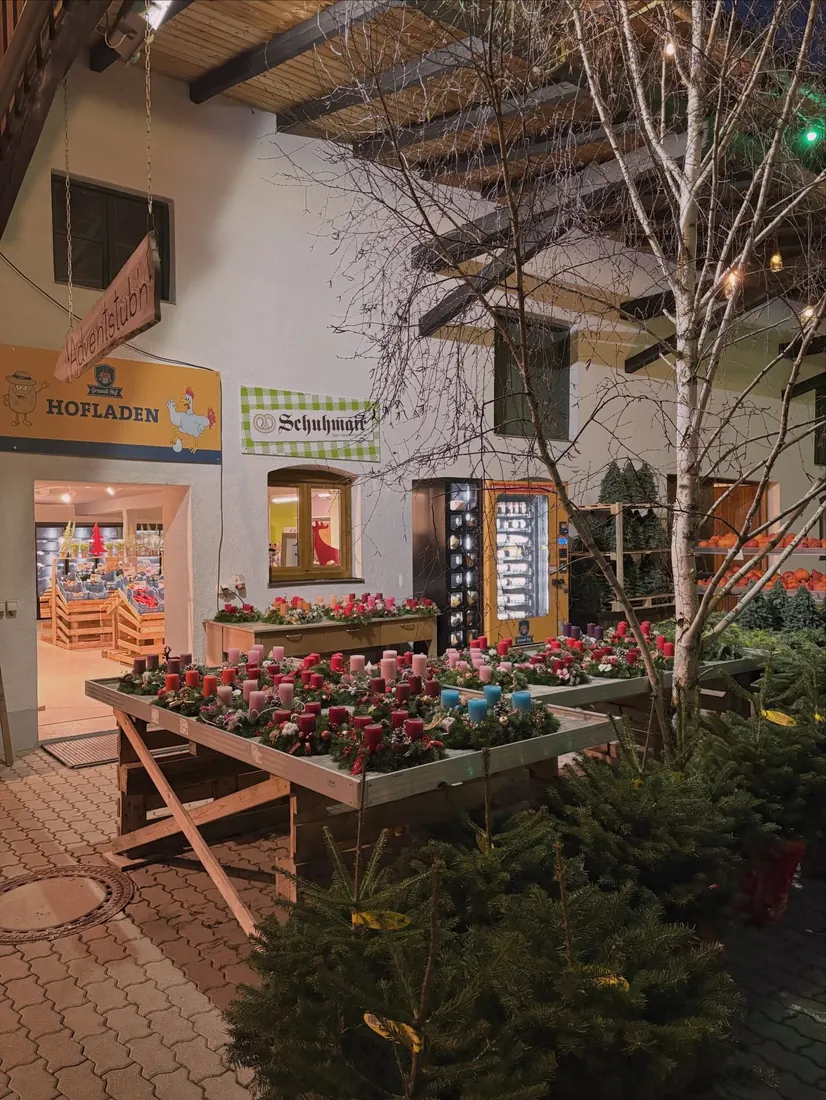 Eingang zum Hofladen mit Blumen und Christbäumen